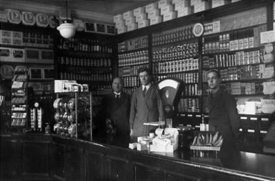 3 män stående bakom disken i affär.
Nyckelord: Affärsinredning