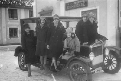 6 kvinnor sittande och stående på bil.
Nyckelord: Bil