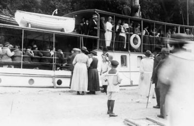 Ett antal personer på kaj och på båt.
Nyckelord: Dräkt