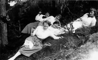 5 liggande kvinnor i skogsbacke.
Nyckelord: Skogsbacke Vinflaska