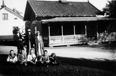 Familj framför byggnad.
