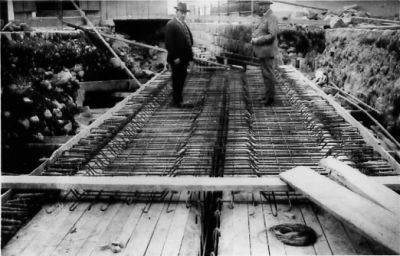 2 män stående på byggarbetsplats.
