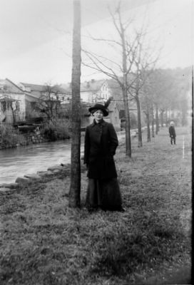 Kvinna stående bredvid vattendrag.
