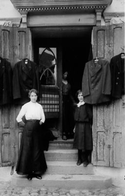 2 kvinnor stående i affärsdörr.
