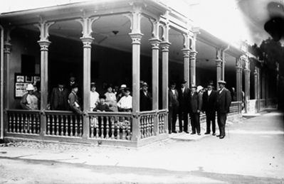 Ett antal personer stående vid byggnad.
