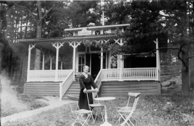 Kvinna stående vid trädgårdsmöbel framför byggnad.
Nyckelord: Trädgårdsmöbler