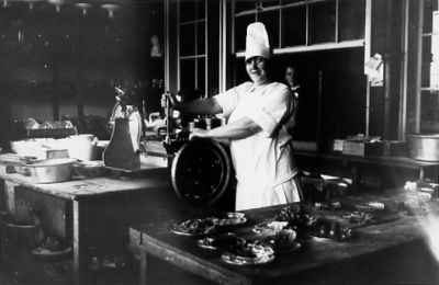 Kvinna stående i kök.
