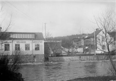 Vattendrag med byggnad i bakgrunden.
