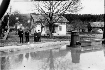 2 män och 2 kvinnor stående vid vattendrag.
