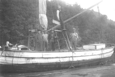 4 män och 1 kvinna stående på båt.
Nyckelord: Skuta