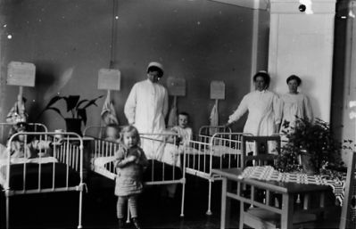 3 kvinnor o 3 barn i och vid sängar.
Nyckelord: Säng Uniform