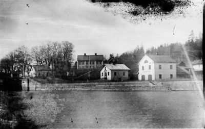 Vattendrag med byggnader i bakgrunden.
