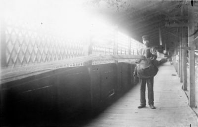 Man stående under ett tak.
Nyckelord: Repslageri