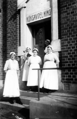 5 kvinnor stående på trappa.
Nyckelord: Trappa Räcke Dräkt