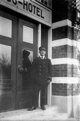 Man stående på trappa till byggnad.
