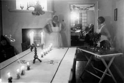 2 kvinnor stående vid julbord.
Nyckelord: Krubba Ljusstakar