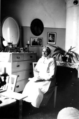 Kvinna sittande på stol.
Nyckelord: Uniform