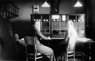 2 kvinnor sittande framför växelbord.
Nyckelord: Telefonväxel