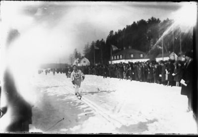 Man åkande i skidspår och inför publik.
Nyckelord: Vinter