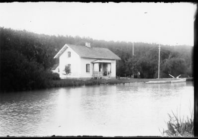 Vattendrag med byggnad i bakgrunden.
