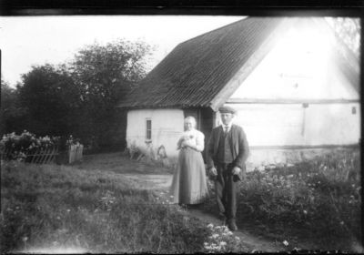 Man och kvinna stående framför byggnad.

