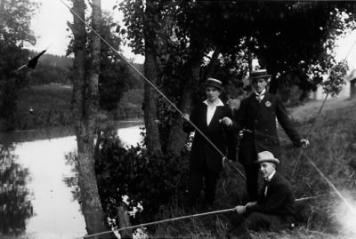 3 män med metspön vid vattendrag.
