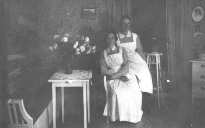 2 kvinnor sittande i rum.
Nyckelord: Blommor Uniform