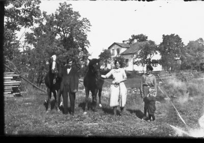 Man och kvinna stående med varsin häst. Pojke och barn stående bredvid.
Nyckelord: Häst