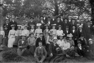 Festklädda män och kvinnor i skogsbacke
Nyckelord: Dräkt