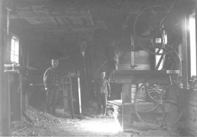 Man och 3 pojkar i verkstad
Nyckelord: såg