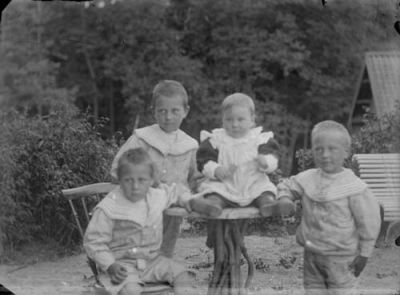 4 pojkar vid trädgårdsmöbel
