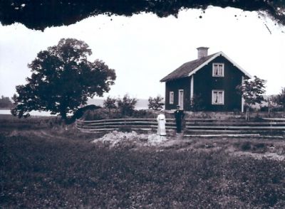 Man och kvinna framför byggnad vid sjö
