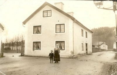 1 kvinna och 1 pojke framför en byggnad
