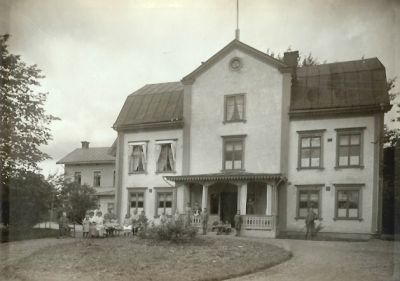 En grupp människor på gårdsplanen framför en byggnad
