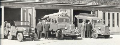 4 män med brandbilar framför brandstation
Nyckelord: Brandbil