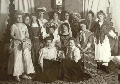 14 uppklädda kvinnor i rum
Nyckelord: Dräkt
