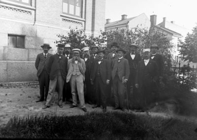 12 män framför byggnad
