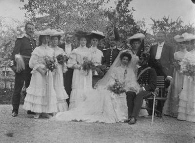 Brudpar med bröllopsfölje utomhus
Nyckelord: Uniform Dräkt Hatt Sabel Brudbukett Bröllop