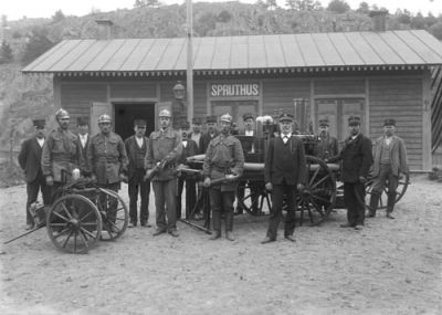 Brandstyrka framför byggnad
Nyckelord: Brandspruta Brandman Uniform Klockkedja