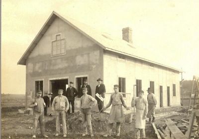 11 personer framför husbygge
Nyckelord: Ok