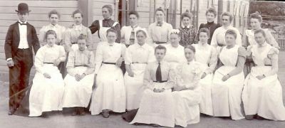 2 män och 18 kvinnor utanför byggnad
Nyckelord: Dräkt