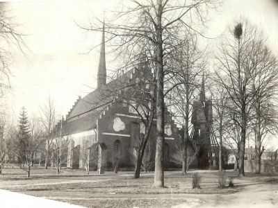 Stenkyrka och klockstapel i park
