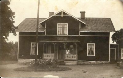 Familj stående på veranda till byggnad
