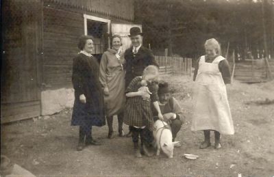 2 män 3 kvinnor 1 flicka och 1 gris på ladugårdsbacke
Nyckelord: Gris Dräkt Docka Hatt Gärdesgård
