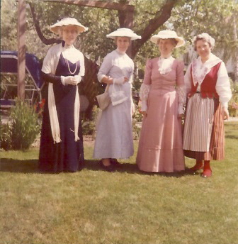 4 festklädda kvinnor på gräsmatta
Nyckelord: Dräkt