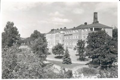 Stor stenbyggnad omgiven av park
