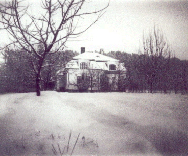 Större villa i snöklätt landskap
