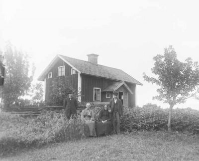 2 män och 2 kvinnor framför hus
Nyckelord: Dräkt