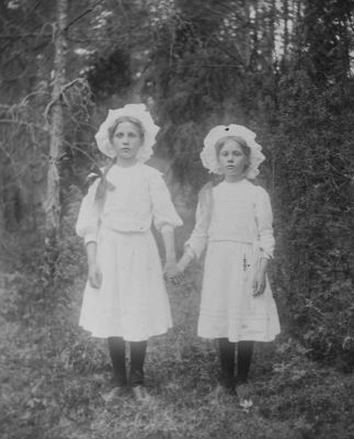 2 flickor stående i skogen
Nyckelord: Dräkt