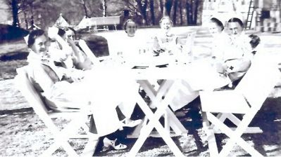 8 sköterskor runt trädgårdsbord
